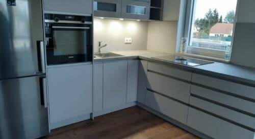 Küchenstudio Eine kleine Küche mit Kühlschrank und Spüle.