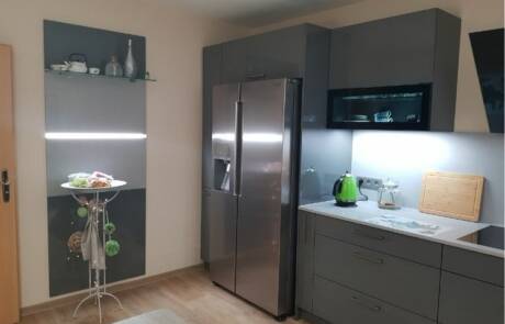 Küchenstudio Eine kleine Küche mit Kühlschrank und Mikrowelle.