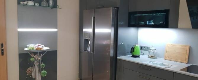 Küchenstudio Eine kleine Küche mit Kühlschrank und Mikrowelle.