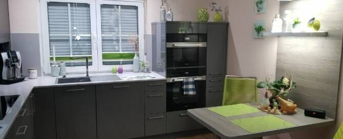 Küchenstudio Eine kleine Küche mit Tisch und Stühlen.