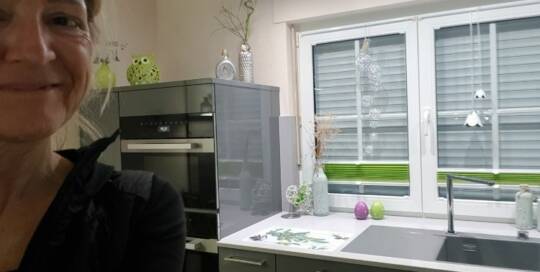 Küchenstudio Eine Frau steht vor einer Küche.