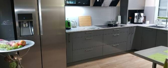Küchenstudio Eine Küche mit Küchengeräten aus Edelstahl und Holzböden.