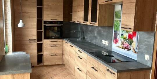 Küchenstudio Eine Küche mit Holzschränken und Arbeitsplatten.