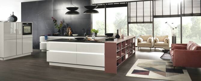 Küchenstudio Eine moderne Küche mit großer Kochinsel und Stühlen, entworfen von Küchenplanung Rostock.
