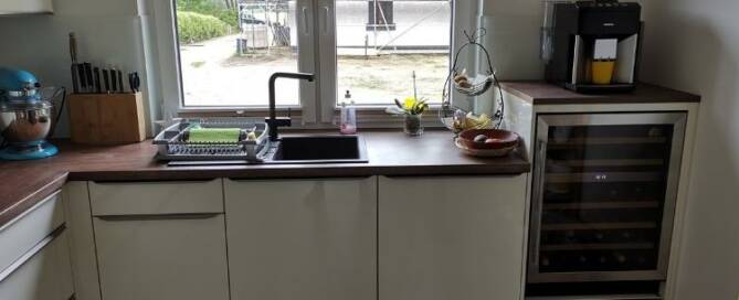 Küchenstudio Eine kleine Küche mit Kühlschrank und Spüle.
