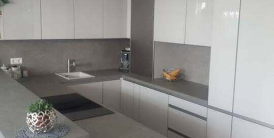 Küchenstudio Eine Küche mit weißen Schränken und Arbeitsplatten.