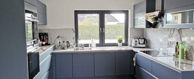 Küchenstudio Eine Küche mit blauen Schränken und Holzböden.