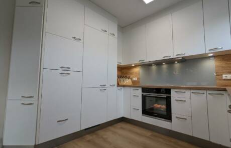 Küchenstudio Eine Küche mit weißen Schränken und Holzböden.