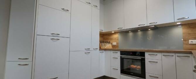 Küchenstudio Eine Küche mit weißen Schränken und Holzböden.