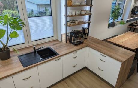 Küchenstudio Eine Küche mit Arbeitsplatten aus Holz und einem Waschbecken.