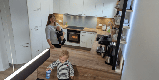 Küchenstudio Eine Frau und ein Kind stehen in einer Küche.