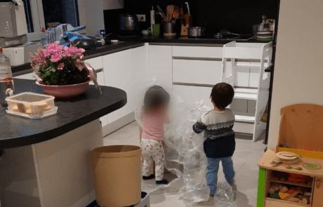 Küchenstudio Zwei Kinder spielen in einer Küche mit Plastiktüten.
