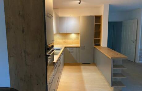 Küchenstudio Eine Küche mit Holzboden und Holzschränken.