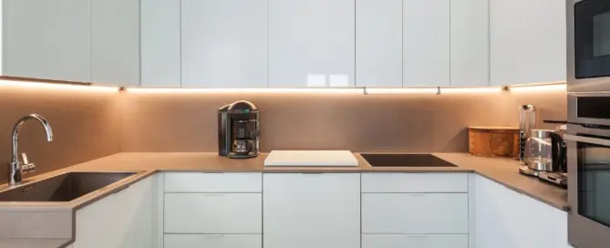 Küchenstudio Eine moderne Küche mit weißen Schränken und Geräten aus Edelstahl.