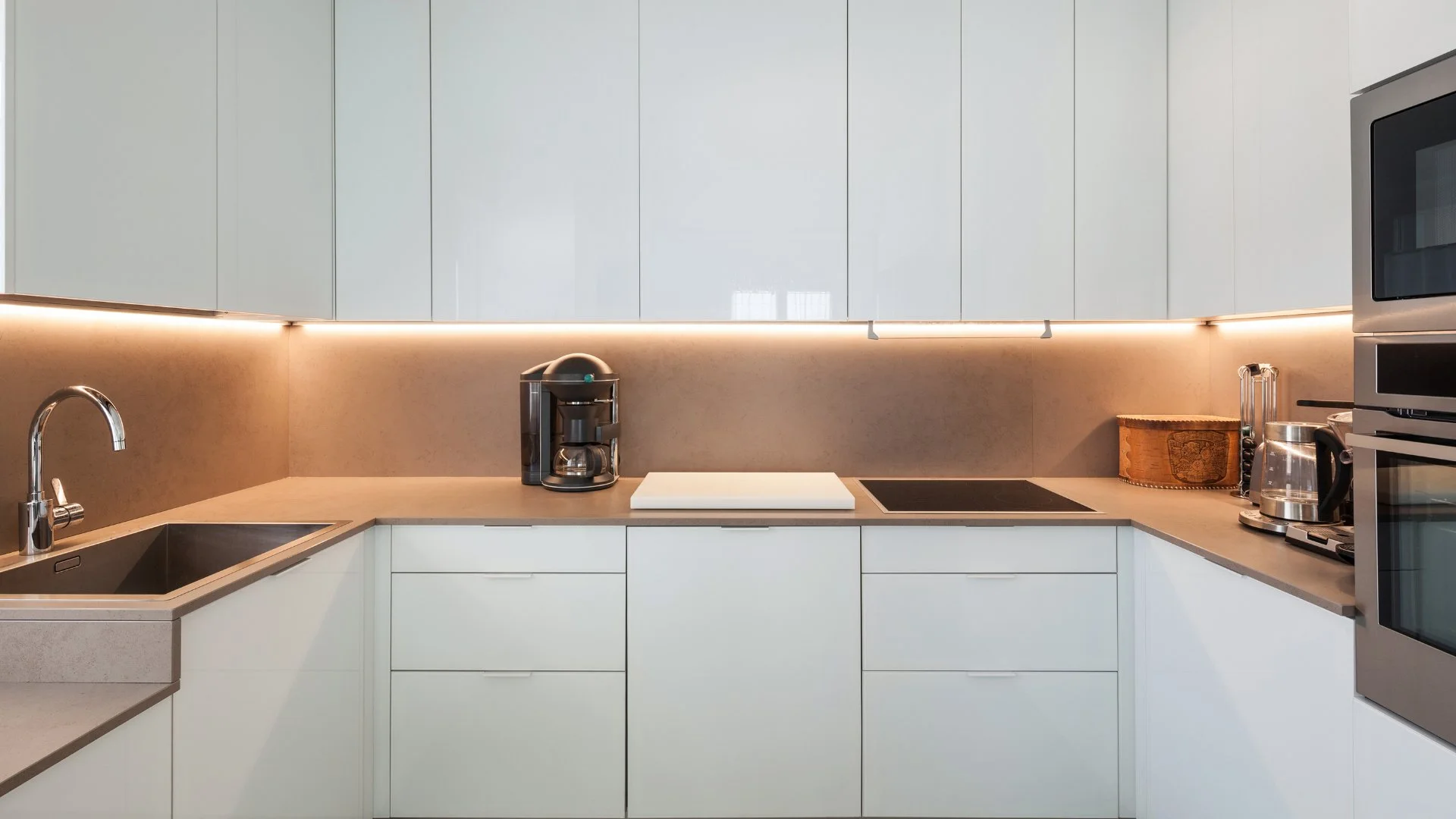 Küchenstudio Eine moderne Küche mit weißen Schränken und Geräten aus Edelstahl. Küchenstudio Eine moderne Küche mit weißen Schränken und Geräten aus Edelstahl.
