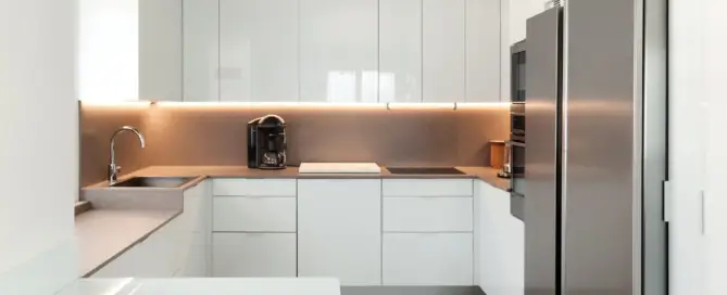 Küchenstudio Eine moderne Küche mit weißen Schränken und Geräten aus Edelstahl.