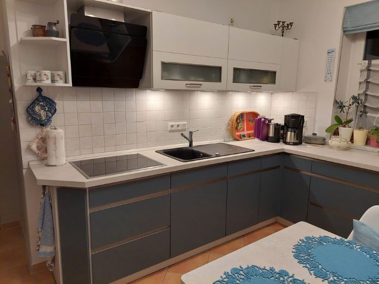 Küchenstudio Eine kleine Küche mit blauen und weißen Geräten.