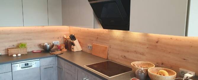Küchenstudio Eine Küche mit einer Holzwand und einem Herd.