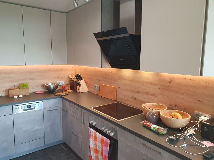 Küchenstudio Eine Küche mit einer Holzwand und einem Herd.