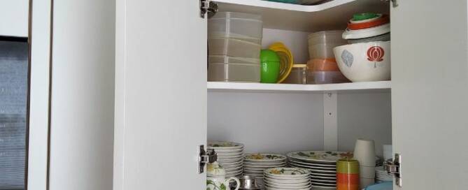Küchenstudio Eine Küche mit einem Eckschrank voller Geschirr.