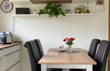 Küchenstudio Eine kleine Küche mit Tisch und Stühlen.