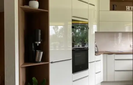 Küchenstudio Eine moderne Küche mit weißen Schränken und Holzböden.