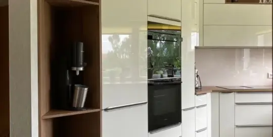 Küchenstudio Eine moderne Küche mit weißen Schränken und Holzböden.