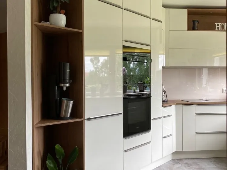 Küchenstudio Eine moderne Küche mit weißen Schränken und Holzböden.