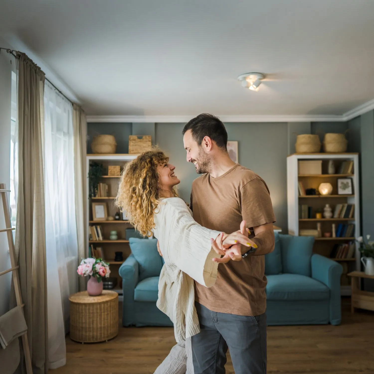 Glueckliches Paar tanzt im Wohnzimmer