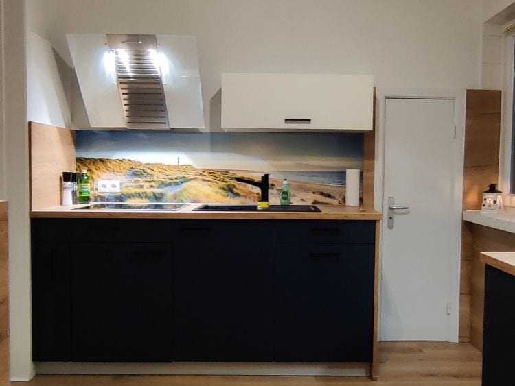 Küchenstudio Eine Küche oder Küchenzeile mit einem Bild an der Wand.