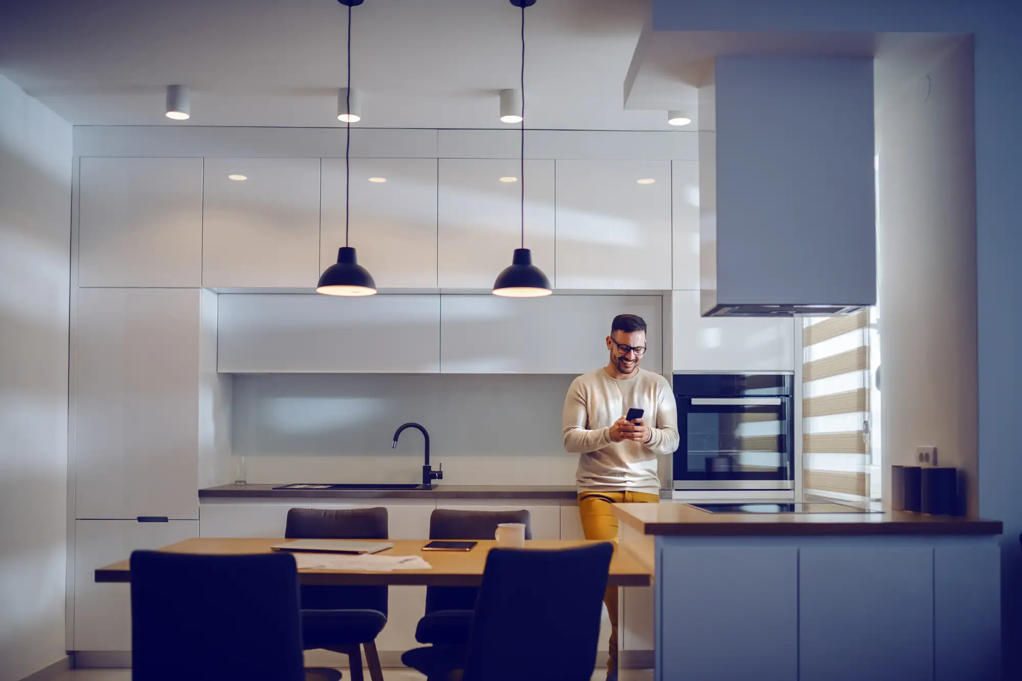 Mann-in-Kueche Ein Mann freut sich nach dem Küchenaufmaß über seine neue Küche, die perfekt in den Raum passt. Aufmaß