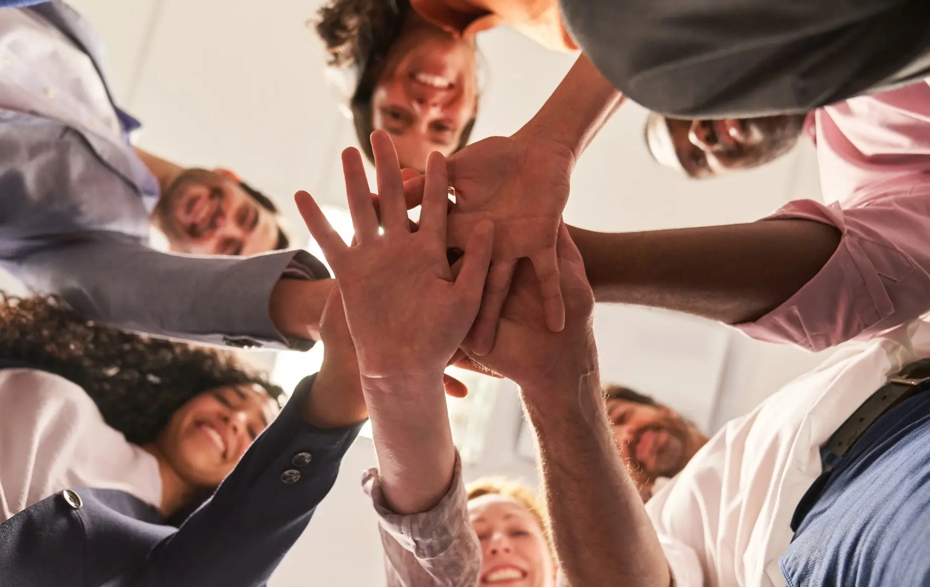 Küchenstudio Eine Gruppe von Menschen, die in einem Kreis stehen, legen ihre Hände in der Mitte zusammen, von unten gesehen, als Symbol für Teamwork, Einigkeit und gemeinsame Karriereziele. Küchenstudio Eine Gruppe von Menschen, die in einem Kreis stehen, legen ihre Hände in der Mitte zusammen, von unten gesehen, als Symbol für Teamwork, Einigkeit und gemeinsame Karriereziele.