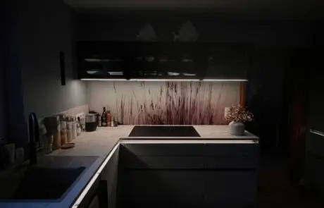 Küchenstudio Moderne Küche mit dunklen Schränken, Unterbauleuchten, einem Kochfeld und einer Küchenrückwand mit botanischem Muster. Auf den Arbeitsplatten stehen verschiedene Küchenutensilien und eine Topfpflanze. Küchenstudio Moderne Küche mit dunklen Schränken, Unterbauleuchten, einem Kochfeld und einer Küchenrückwand mit botanischem Muster. Auf den Arbeitsplatten stehen verschiedene Küchenutensilien und eine Topfpflanze.